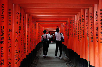 Rear view of men walking in temple