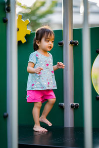 Full length of girl standing on play equipment