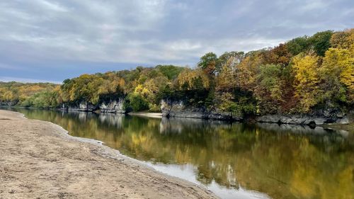 Scenic view of lake by trees against sky