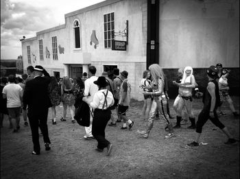 People walking on street in front of city