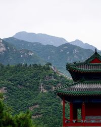 Low angle view of historic building against green mountains