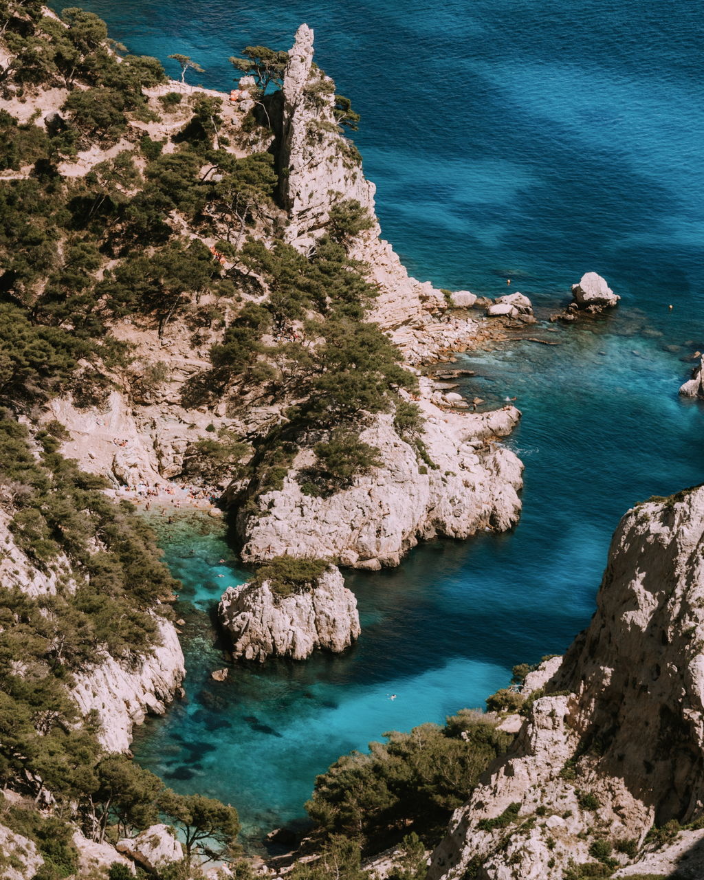 HIGH ANGLE VIEW OF ROCK FORMATIONS ON SEA