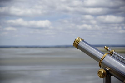 Close-up of coin-operated binoculars against sky