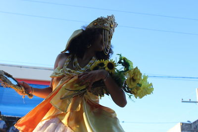 Low angle view of woman against blue sky