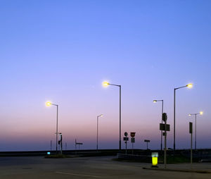 Street lights against clear sky at sunset