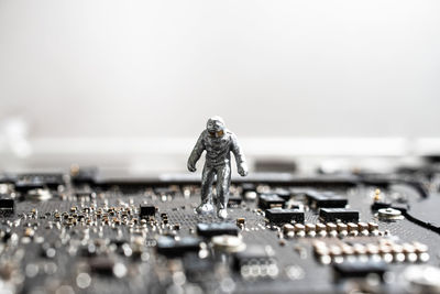 Close-up of figurine on metal against white background