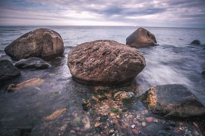 Rocks in sea against sky