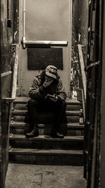 Full length of woman sitting on staircase