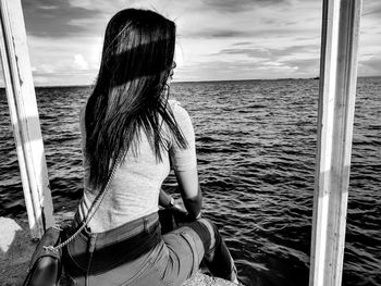 Rear view of woman looking at sea against sky