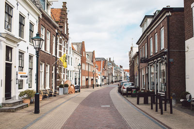 Empty road amidst buildings in city