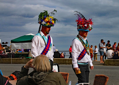 Group of people in traditional clothing against sky