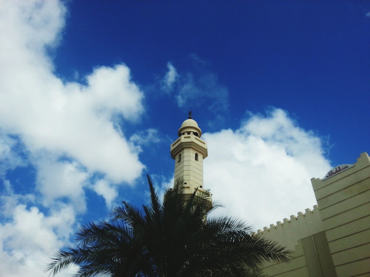 architecture, low angle view, building exterior, built structure, sky, blue, cloud - sky, tree, cloud, tower, tall - high, high section, day, outdoors, cloudy, no people, city, building, tall, travel destinations