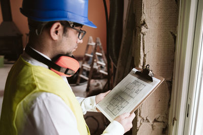 Foreman or architect working on blueprints on construction site. home improvement