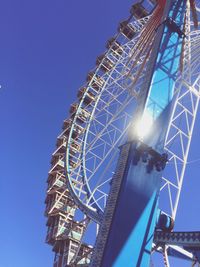Low angle view of ferris wheel against blue sky