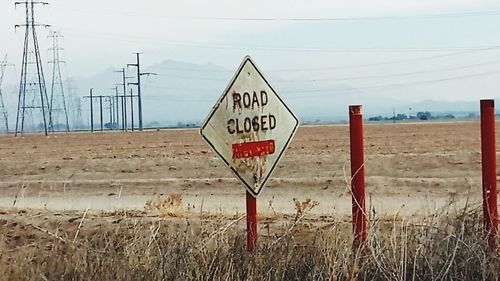 Information sign on road against sky