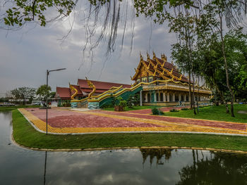 Building by lake against sky