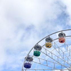 Low angle view of ferris wheel against cloudy sky