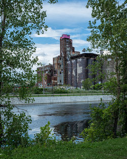 View of buildings by lake against sky