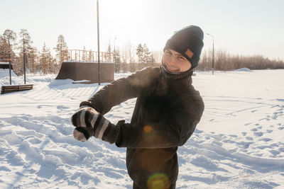 Winter outdoor activities. close-up of a handsome man, warming up before jogging in a snow park