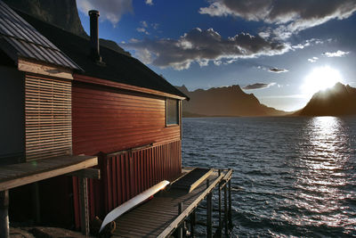 Scenic view of sea and buildings against sky at sunset