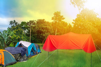 Tent on field by trees against sky