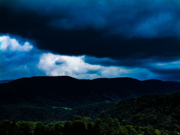 Scenic view of mountains against storm clouds