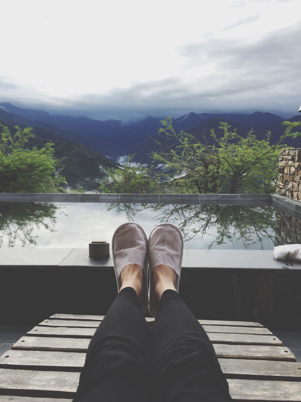 personal perspective, low section, person, mountain, shoe, water, lake, sky, mountain range, river, railing, lifestyles, men, relaxation, nature, tree, tranquil scene