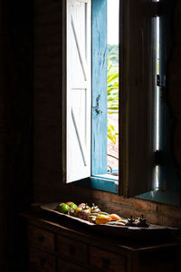 Potted plant on table by window in house