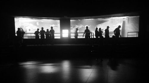 Silhouette people standing in illuminated corridor