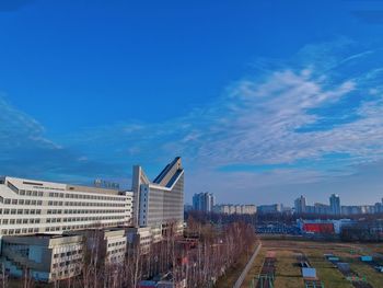 Modern buildings in city against blue sky