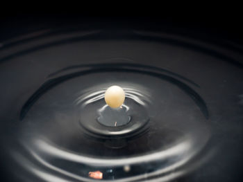 High angle view of lit candle in water