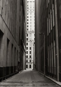 Empty road amidst buildings in city