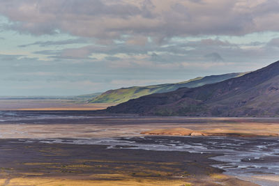 Scenic view of sea and mountains against sky