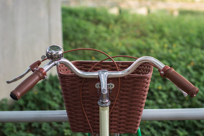 Close-up of bicycle basket against plants