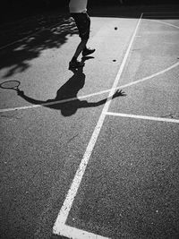 Low section of man skateboarding on road