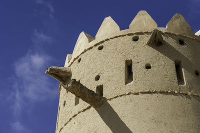 Low angle view of cross on building against sky