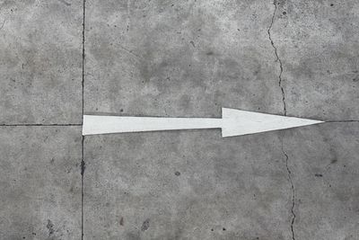 Close-up of arrow sign on wall