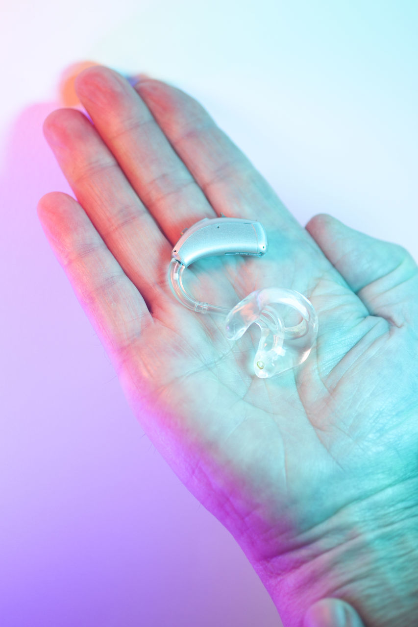 CLOSE-UP OF HUMAN HAND HOLDING BLUE BACKGROUND