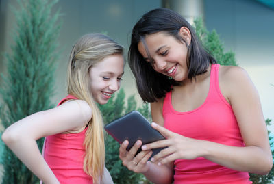 Teenage siblings using digital tablet