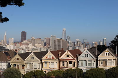 Buildings in city against clear sky