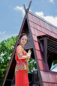 Young woman standing against building