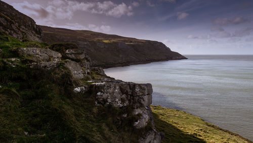 Rock formations by sea against sky