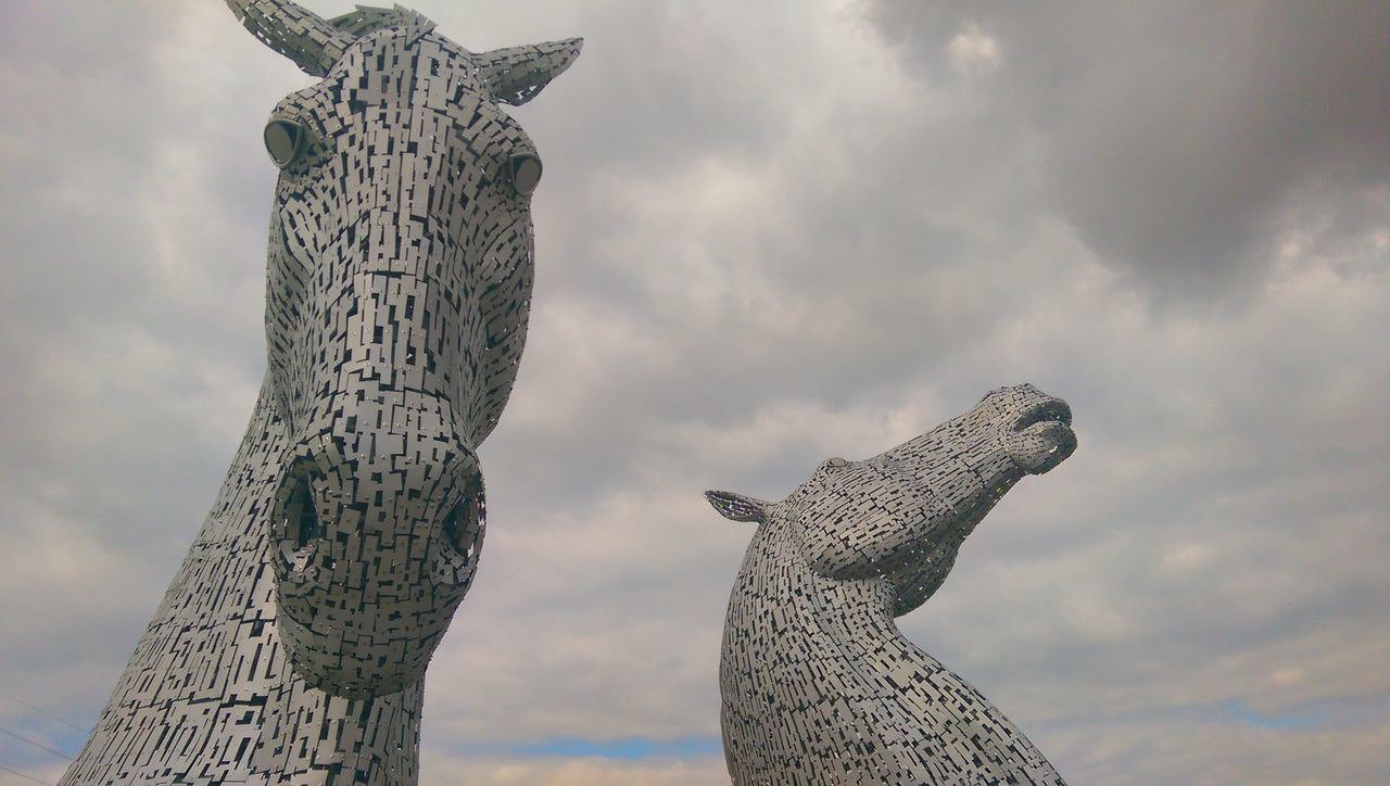 LOW ANGLE VIEW OF STATUES AGAINST SKY IN CITY