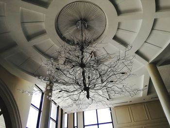 Low angle view of illuminated chandelier hanging from ceiling