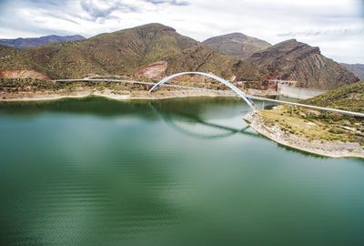 Scenic view of dam and mountains against sky