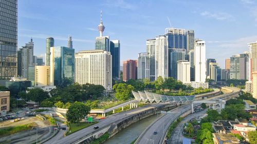 Road amidst buildings in city against sky