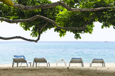 Chairs on beach against clear sky