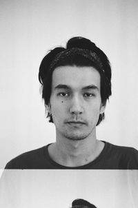 Portrait of young man standing against wall