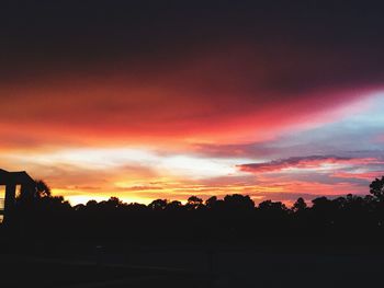 Silhouette of trees against cloudy sky