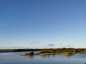 Scenic view of lake against clear blue sky